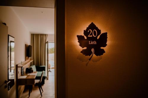 a room with a sign on the wall with a living room at Weinzuhause Hotel-Restaurant-Vinothek in Mommenheim