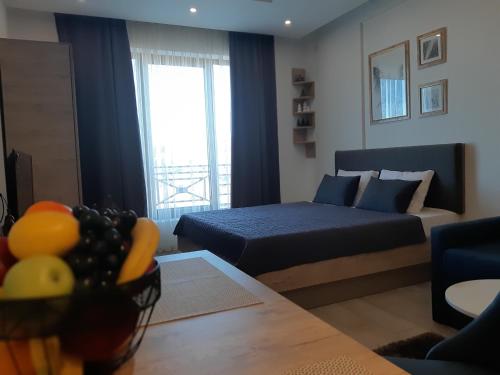 a living room with a bed and a table in a room at Dream Milmari L12 Apartman in Kopaonik