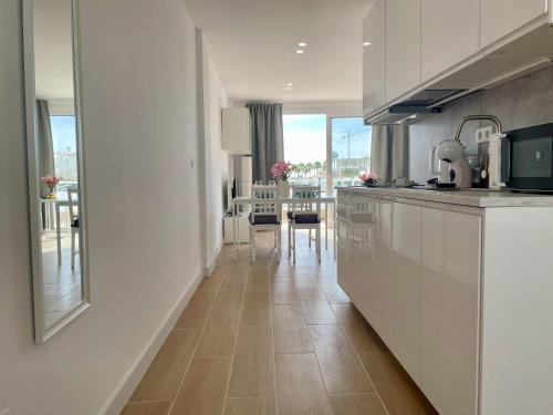 a kitchen with white cabinets and a dining room at Malibu Park 3078 - Ocean View Studio in Adeje