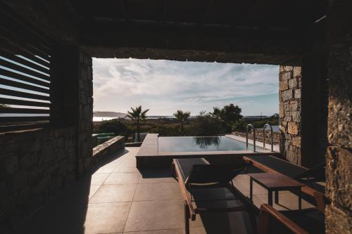 a hot tub on the patio of a house at Kouros Blanc Resort & Suites in Pounda