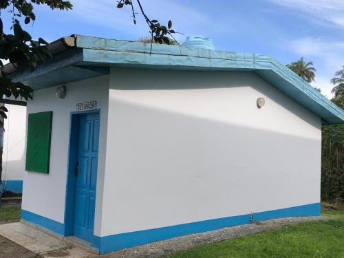 a small white and blue building with a blue door at OCEAN-SI Mansion in Kribi