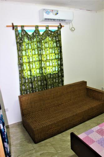 a brown couch in a room with a window at OCEAN-SI Mansion in Kribi