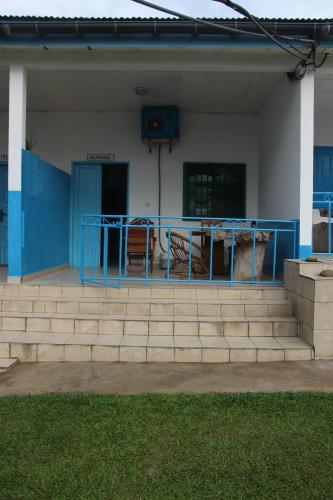 a building with a blue railing and some stairs at OCEAN-SI Mansion in Kribi