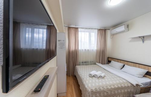 um quarto de hotel com uma cama e uma televisão em Studiia na Beresteiskoi em Kiev