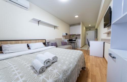 キーウにあるStudiia na Beresteiskoiのベッドルーム1室(白いベッド1台、タオル付)