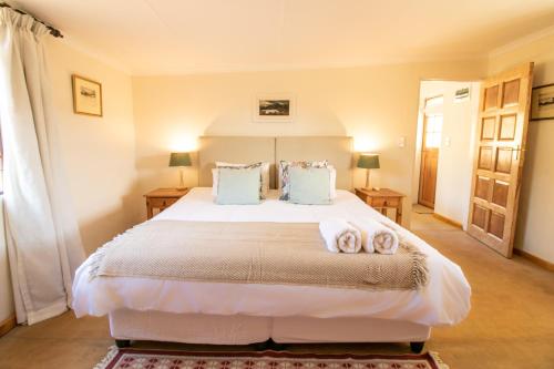 - une chambre avec un grand lit et 2 serviettes dans l'établissement Sunbird Cottage, à Graaff-Reinet