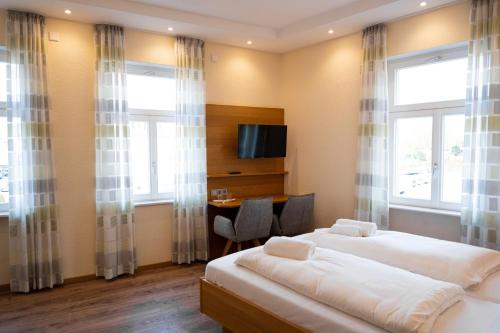 a hotel room with two beds and a desk at Gasthause Zur Krone Hotel in Leimen