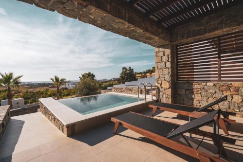 a patio with a pool and a table and chairs at Kouros Blanc Resort & Suites in Pounda