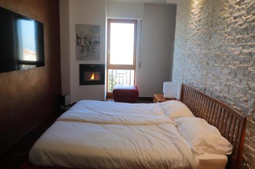 a bed in a bedroom with a brick wall at Stanza in Appartamento incantevole con camino Adelfia Bari in Adelfia