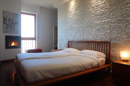 1 dormitorio con 1 cama grande y pared de ladrillo en Stanza in Appartamento incantevole con camino Adelfia Bari, en Adelfia