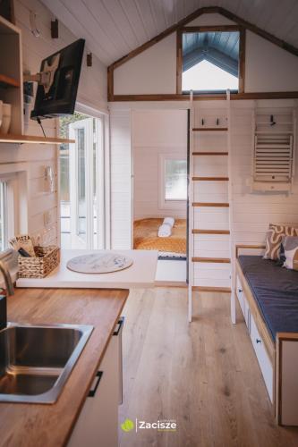 a tiny house with a kitchen and a bedroom at Półwysep Zacisze - Tiny House Village in Przywidz