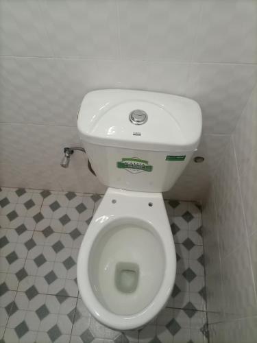a bathroom with a white toilet in a stall at Pearl Motel Buloba in Buloba