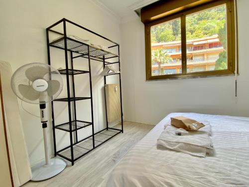 Zimmer mit einem Bett, einem Ventilator und einem Fenster in der Unterkunft "La Cuse" Vue Mer Imprenable, Calme, Parking in Menton