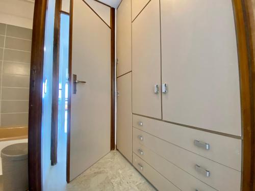 ein Badezimmer mit weißen Schränken und einem Spiegel in der Unterkunft "La Cuse" Vue Mer Imprenable, Calme, Parking in Menton