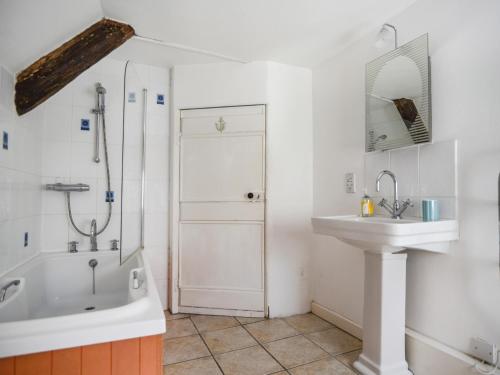 a bathroom with a tub and a sink and a shower at Old Cross Cottage in Whitchurch Canonicorum