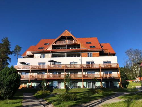 a large white building with a red roof at APARTMÁN RIVIÉRA LIPNO 511-16 in Lipno nad Vltavou