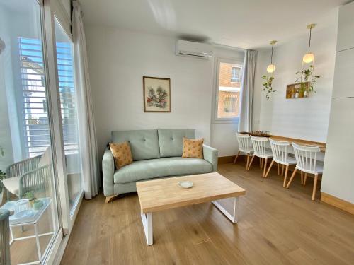 un soggiorno con un divano e un tavolo di LOFT DELUXE ALMA GARDEN a Cordoba