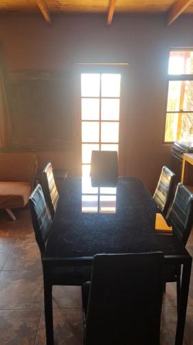 a dining room with a black table and chairs at Lodge Altitud in San Pedro de Atacama