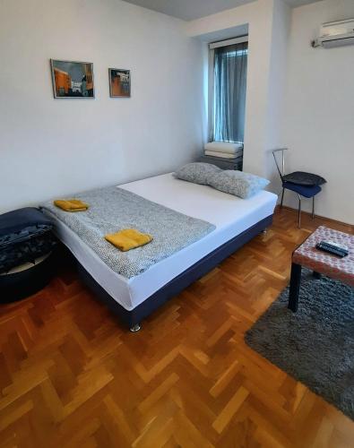 a bedroom with a bed and a wooden floor at Stan na dan u centru, Inđija in Inđija