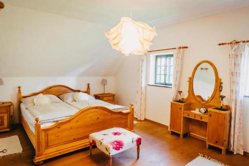 1 dormitorio con cama de madera y espejo en Waldjuwel Mostviertel en Allhartsberg