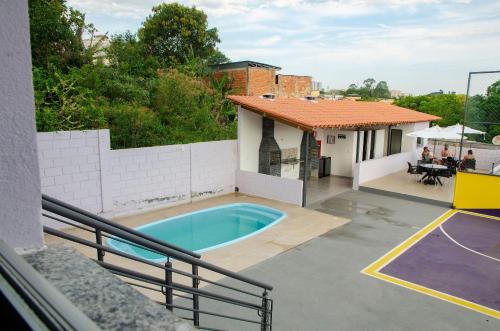 a house with a swimming pool and a basketball court at Studio 900m do centro, prédio com piscina, sauna, academia e lavanderia in São João del Rei