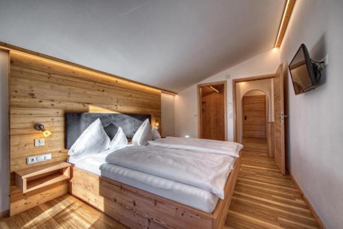 a bedroom with a large bed in a wooden wall at Alpenhof Ferienwohnungen in Oberstaufen
