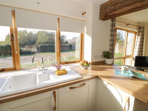 a kitchen with a sink and a window at Granary Cottage in Southam