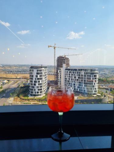 a wine glass sitting on a table in front of a window at Ellipse Apartment in Midrand