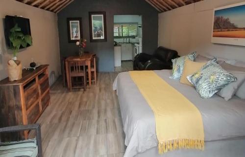 een slaapkamer met een groot bed en een woonkamer bij Overflow Cottage in Clarens