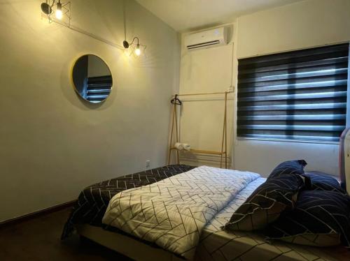 Schlafzimmer mit einem Bett, einem Spiegel und einem Fenster in der Unterkunft The Berlian Guesthouse - Two beedroom Apartment with Pool View in Port Dickson