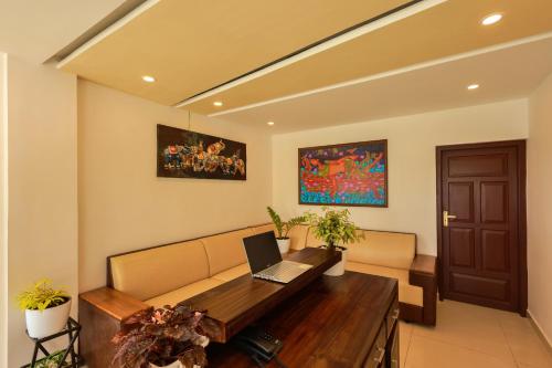 a living room with a couch and a laptop on a table at The Windy Mist Resort Munnar in Chinnakanal