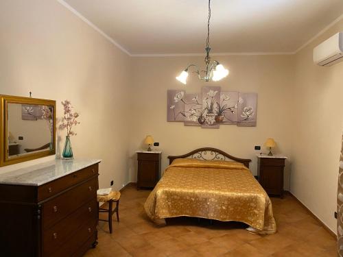 1 dormitorio con cama, tocador y espejo en Villa Piruzzu CV Torre Mulinazzo app P en Cinisi