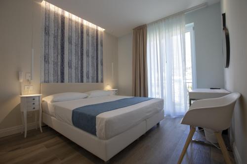 a bedroom with a large bed and a window at Luxmarì Hotel & Spa in Castellammare del Golfo