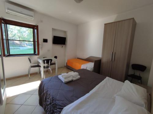 a bedroom with a bed and a desk and a window at Parco d'Arte AltArt in Rende
