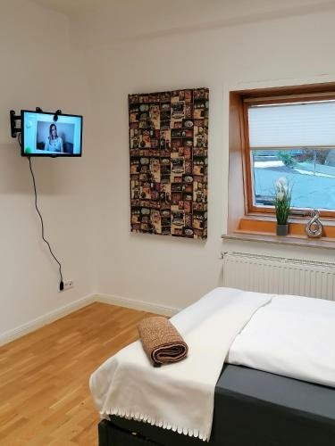 ein Schlafzimmer mit einem Bett und einem TV an der Wand in der Unterkunft AufmLohr - Appartement mit 3 Schlafzimmern - in Leverkusen Hitdorf - Private Parkplätze vorhanden- in Leverkusen