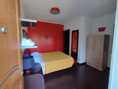 a bedroom with a bed and a red wall at Parco d'Arte AltArt in Rende