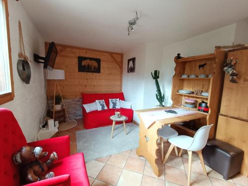 uma sala de estar com mobiliário vermelho e um sofá vermelho em Appartement avec terrasse et parking Privé em Aigueblanche