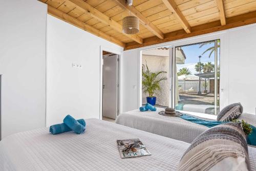 プエルト・デ・サンティアゴにあるVilla Bolsón by W Tenerifeの大きな窓付きの客室で、ベッド2台が備わります。