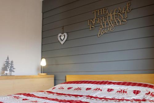 um quarto com uma cama com uma colcha vermelha e branca em CASA 4 PIOPPI - Privacy e panorama em Cavalese