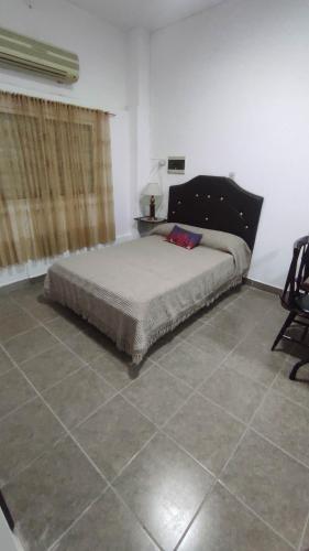 een slaapkamer met een bed en een stoel erin bij MONOAMBIENTE YERBA BUENA in Yerba Buena