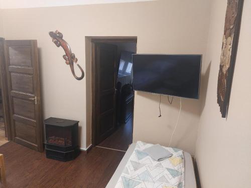 a room with a flat screen tv hanging on the wall at Fehér galamb apartman in Gyál