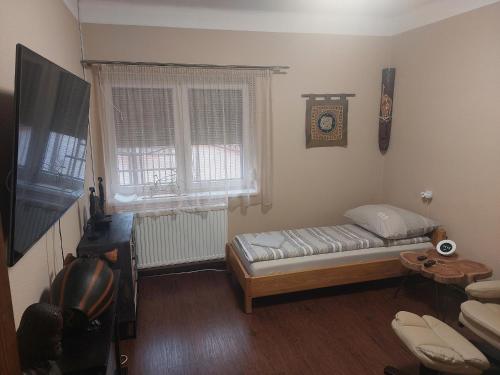 Habitación pequeña con cama y ventana en Fehér galamb apartman, en Gyál