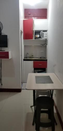 a small kitchen with a table and a refrigerator at Innsite Room Rentals in Manila