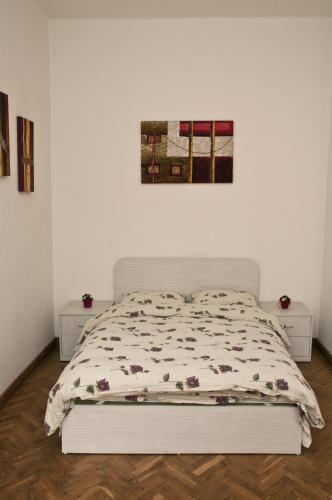 a bed in a white room with a bedspread at Hostel Mostel Sofia in Sofia