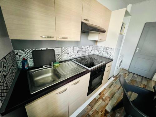 une cuisine avec un évier et une cuisinière dans l'établissement La Plume Wifi Parking Un-Séjour-à-Part, à Clouange