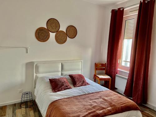 a bedroom with a bed with two pillows and a window at La Plume Wifi Parking Un-Séjour-à-Part in Clouange
