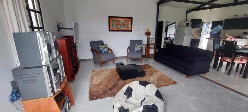 a living room with a couch and a tv at Finca Acogedora - Lago Calima in Calima