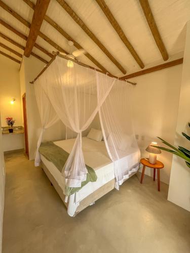 a bedroom with a bed with a mosquito net at Villa Milagre in Trancoso
