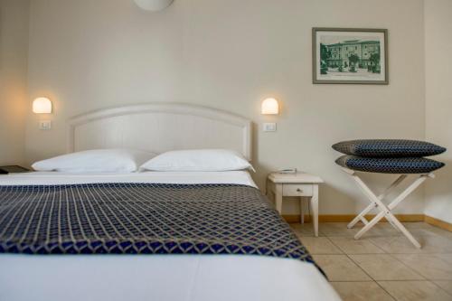 una camera con letto, tavolo e sgabello di Hotel Villa Mare a Riccione