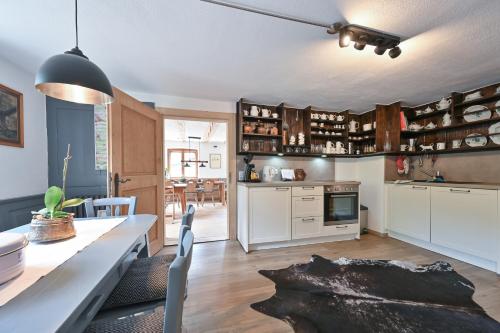 a kitchen with white cabinets and a table with chairs at Exklusives und Modernes Bauernhaus in Nesselwang
